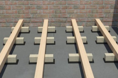 Les grumes sont posées perpendiculairement à la direction des lames de plancher Bûches placées en croix dans le sens des lames de plancher