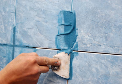 Le coulis pour joints est appliqué sur la tuile avec une spatule en caoutchouc, ce qui vous permet de remplir uniformément les vides inter-tuiles Le coulis pour joints est appliqué sur la tuile avec une spatule en caoutchouc, ce qui vous permet de remplir uniformément les vides inter-tuiles