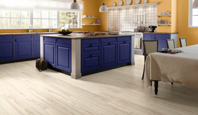 Cuisine avec sols blancs et meubles colorés.