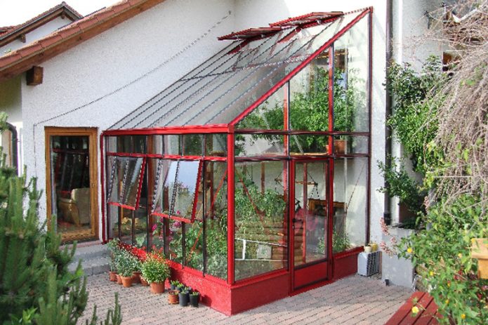 Une petite serre près du mur de la maison