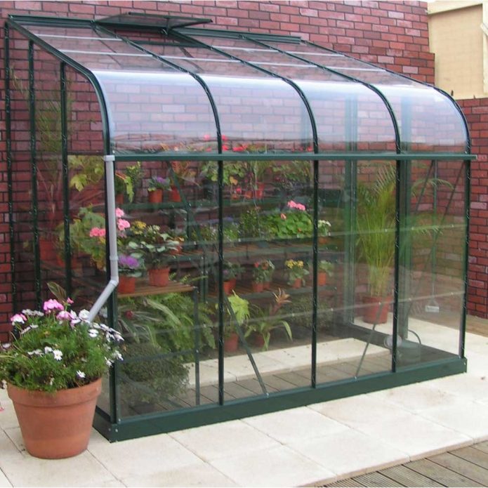 Une petite serre près du mur de la maison