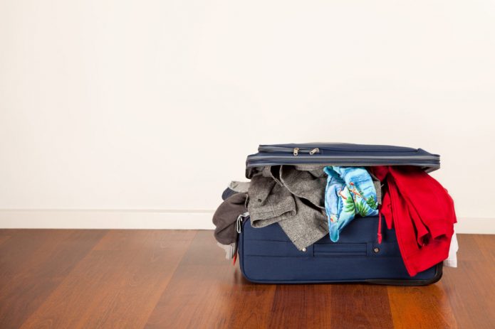 Valise avec des choses sur le sol