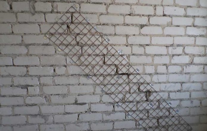 Close up fissure dans le mur de briques à l'aide de treillis métallique