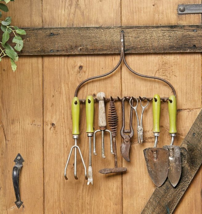 Cintre d'origine pour les outils de jardin sur la porte de la grange