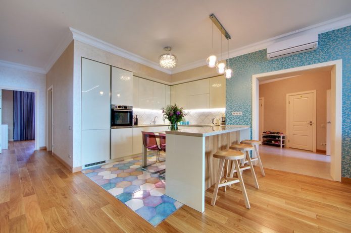 La combinaison des couleurs pastel et du stratifié bois dans la cuisine-salon