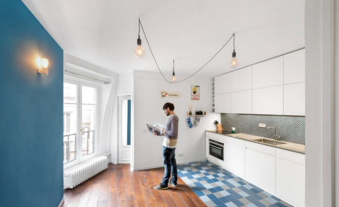 Le sol combiné de leurs carreaux bleus et de bois stratifié dans la cuisine